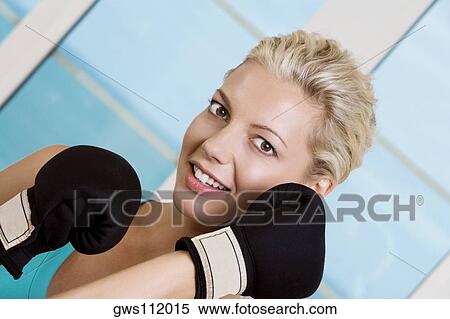 Portrait of a young woman wearing boxing gloves View Large Photo Image Stock Photography - Portrait of a young woman wearing boxing gloves. Fotosearch
