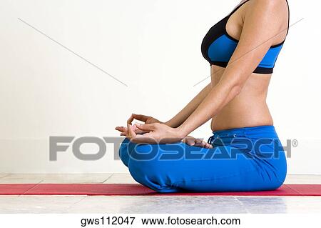 Side profile of a young woman meditating View Large Photo Image Stock Photo - Side profile of a young woman meditating. Fotosearch
