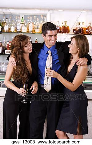 Businessman with his arms around a young woman and a mid adult woman View Large Photo Image Stock Photo - Businessman with his arms around a young woman and a mid adult woman. Fotosearch