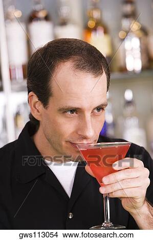 Close-up of a mid adult man drinking a cocktail View Large Photo Image Picture - Close-up of a mid adult man drinking a cocktail. Fotosearch