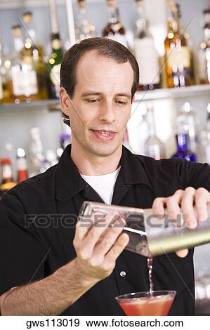 Stock Photo - Close-up of a mid adult man preparing a cocktail. Fotosearch