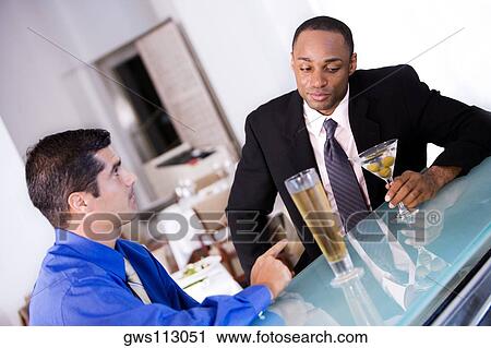 Close-up of two businessmen sitting in a bar View Large Photo Image Stock Image - Close-up of two businessmen sitting in a bar. Fotosearch