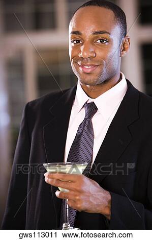 Portrait of a businessman holding a martini glass View Large Photo Image Stock Image - Portrait of a businessman holding a martini glass. Fotosearch