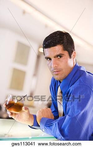 Portrait of a businessman holding a glass View Large Photo Image Stock Image - Portrait of a businessman holding a glass. Fotosearch