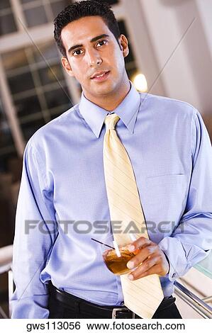 Stock Photograph - Portrait of a businessman holding a glass of wine. Fotosearch