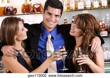 Portrait of a businessman with his arms around a young woman and a mid adult woman View Large Photo Image Stock Image - Portrait of a businessman with his arms around a young woman and a mid adult woman. Fotosearch