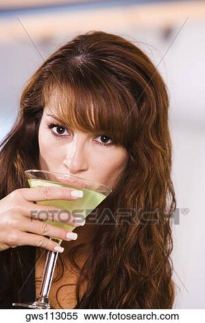 Portrait of a young woman drinking a martini View Large Photo Image Stock Photography - Portrait of a young woman drinking a martini. Fotosearch