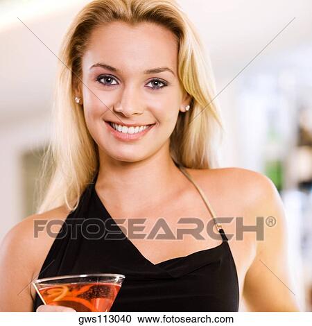 Portrait of a young woman holding a martini glass View Large Photo Image Stock Image - Portrait of a young woman holding a martini glass. Fotosearch
