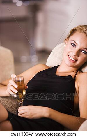 Portrait of a young woman holding a glass of wine View Large Photo Image Stock Photo - Portrait of a young woman holding a glass of wine. Fotosearch