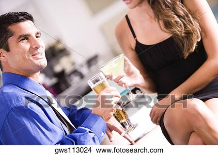 Side profile of a mid adult man and a young woman sitting in a bar View Large Photo Image Picture - Side profile of a mid adult man and a young woman sitting in a bar. Fotosearch