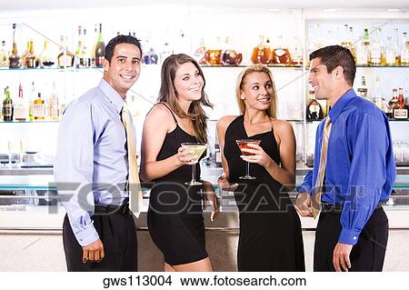 Two mid adult men and two mid adult women standing in a bar View Large Photo Image Picture - Two mid adult men and two mid adult women standing in a bar. Fotosearch