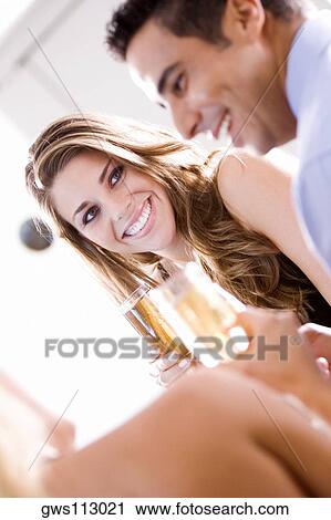 Young woman and a mid adult man holding champagne flutes View Large Photo Image Stock Image - Young woman and a mid adult man holding champagne flutes. Fotosearch