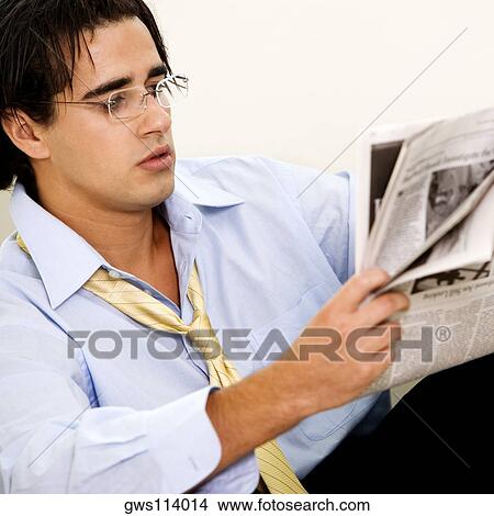 Close-up of a businessman reading a newspaper View Large Photo Image Picture - Close-up of a businessman reading a newspaper. Fotosearch