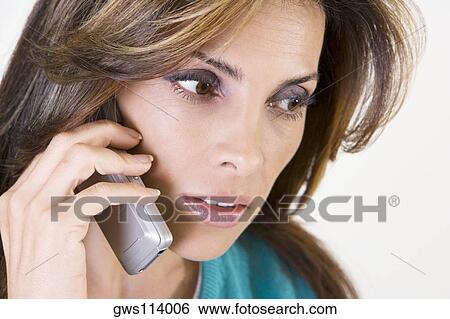 Stock Photograph - Close-up of a mid adult woman talking on a mobile phone. Fotosearch