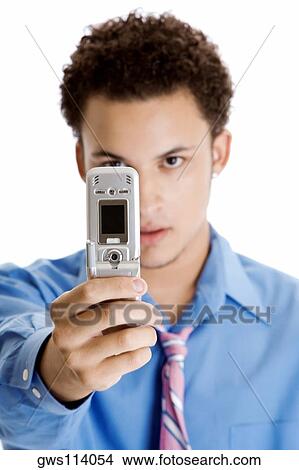 Close-up of a young man taking a photograph with a mobile phone View Large Photo Image Picture - Close-up of a young man taking a photograph with a mobile phone. Fotosearch