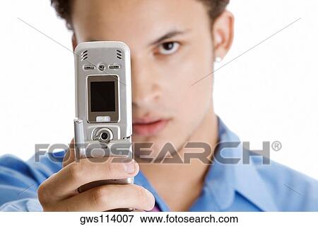 Stock Photo - Close-up of a young man taking a photograph of himself with a mobile phone. Fotosearch