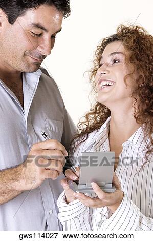 Close-up of a young woman and a mid adult man using a calculator View Large Photo Image Stock Photo - Close-up of a young woman and a mid adult man using a calculator. Fotosearch