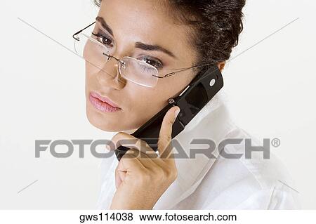 Close-up of a young woman talking on a mobile phone View Large Photo Image Stock Photo - Close-up of a young woman talking on a mobile phone. Fotosearch
