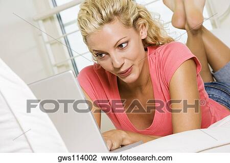 Close-up of a young woman working on a laptop View Large Photo Image Stock Image - Close-up of a young woman working on a laptop. Fotosearch