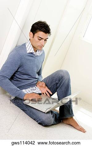High angle view of a mid adult man using a laptop View Large Photo Image Stock Image - High angle view of a mid adult man using a laptop. Fotosearch