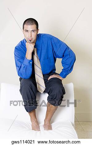 Portrait of a businessman sitting on a chair with his pants rolled up View Large Photo Image Stock Image - Portrait of a businessman sitting on a chair with his pants rolled up. Fotosearch