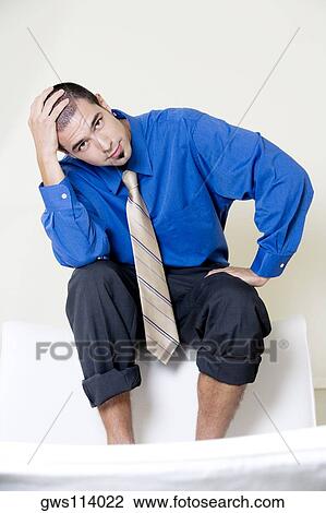Portrait of a businessman sitting on a chair with his pants rolled up View Large Photo Image Stock Image - Portrait of a businessman sitting on a chair with his pants rolled up. Fotosearch