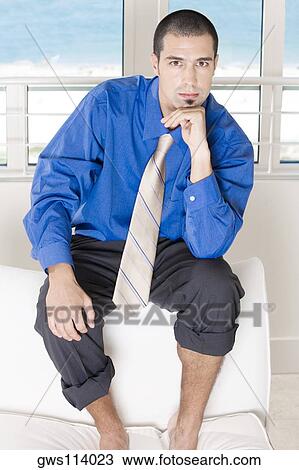 Portrait of a businessman sitting on a couch with his pants rolled up View Large Photo Image Stock Image - Portrait of a businessman sitting on a couch with his pants rolled up. Fotosearch