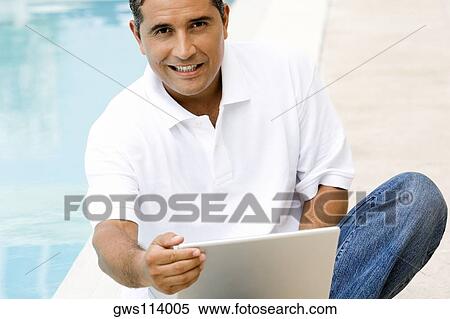 Portrait of a mid adult man using a laptop View Large Photo Image Stock Photography - Portrait of a mid adult man using a laptop. Fotosearch