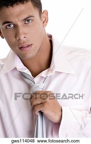 Portrait of a young man adjusting his tie View Large Photo Image Stock Photo - Portrait of a young man adjusting his tie. Fotosearch