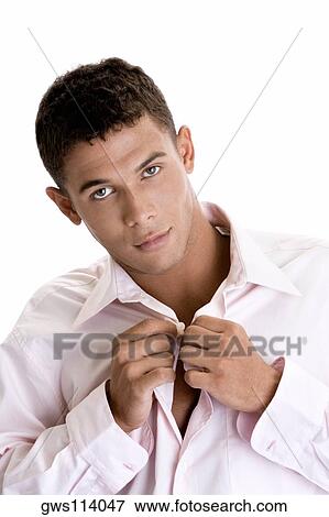 Portrait of a young man buttoning his shirt View Large Photo Image Stock Photo - Portrait of a young man buttoning his shirt. Fotosearch