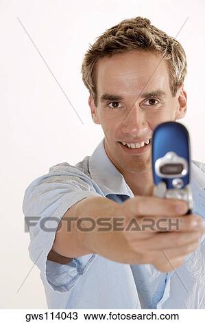 Portrait of a young man holding a mobile phone View Large Photo Image Stock Image - Portrait of a young man holding a mobile phone. Fotosearch