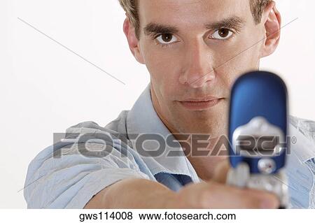 Portrait of a young man holding a mobile phone View Large Photo Image Stock Photo - Portrait of a young man holding a mobile phone. Fotosearch