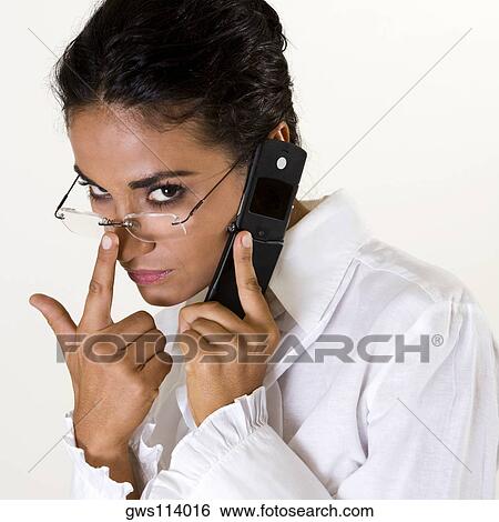 Stock Photograph - Portrait of a young woman talking on a mobile phone. Fotosearch