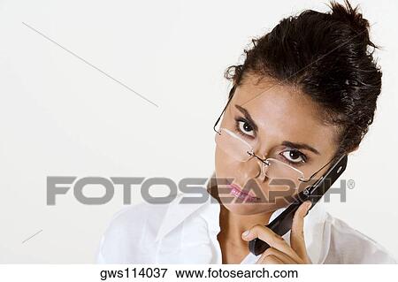 Stock Photo - Portrait of a young woman using a mobile phone. Fotosearch
