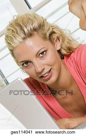 Portrait of a young woman working on a laptop View Large Photo Image Stock Image - Portrait of a young woman working on a laptop. Fotosearch