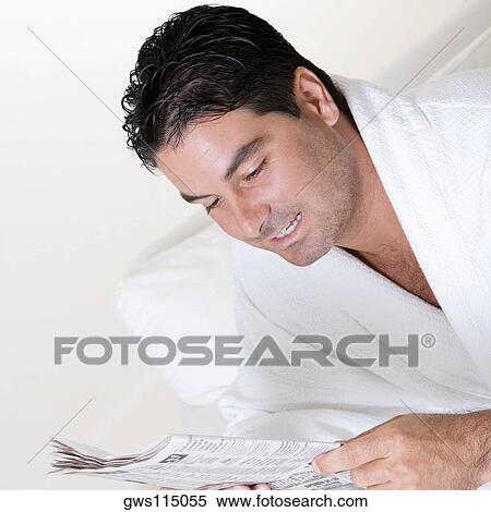 Stock Photography - Close-up of a mid adult man reading a newspaper. Fotosearch