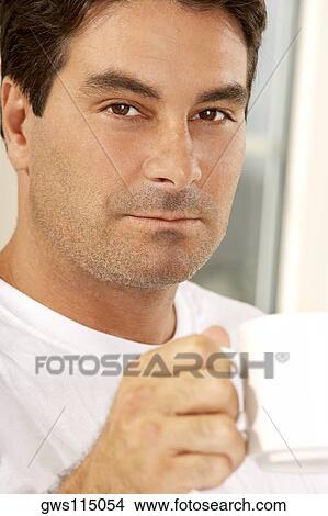 Picture - Portrait of a mid adult man holding a cup of coffee. Fotosearch