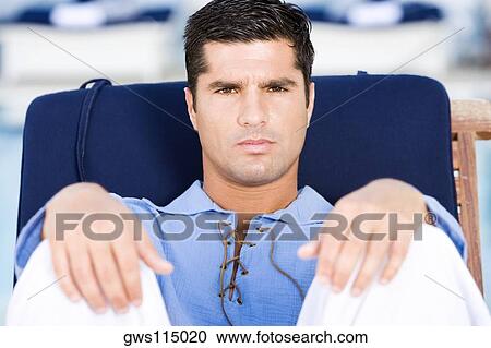 Portrait of a mid adult man relaxing on a chair View Large Photo Image Stock Image - Portrait of a mid adult man relaxing on a chair. Fotosearch
