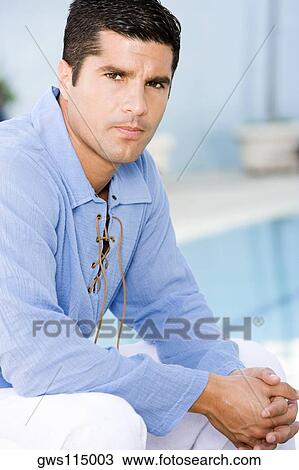 Portrait of a mid adult man sitting with his hands clasped View Large Photo Image Stock Image - Portrait of a mid adult man sitting with his hands clasped. Fotosearch