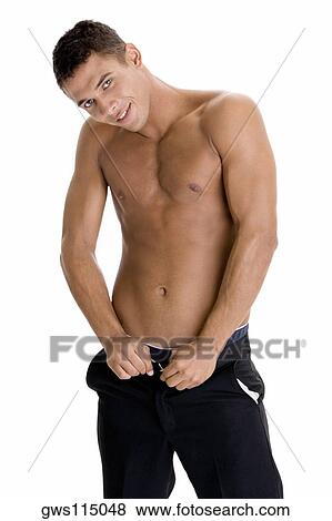 Stock Photo - Portrait of a young man buttoning his pants. Fotosearch