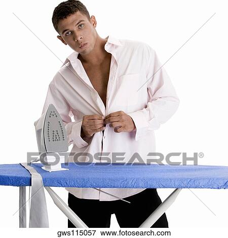 Portrait of a young man buttoning his shirt View Large Photo Image Stock Photo - Portrait of a young man buttoning his shirt. Fotosearch