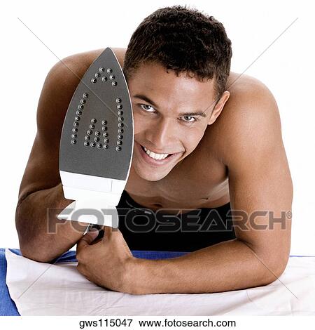 Portrait of a young man holding an iron View Large Photo Image Stock Photo - Portrait of a young man holding an iron. Fotosearch