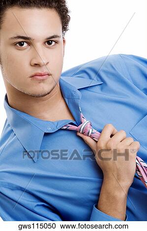 Portrait of a young man holding his tie View Large Photo Image Stock Image - Portrait of a young man holding his tie. Fotosearch