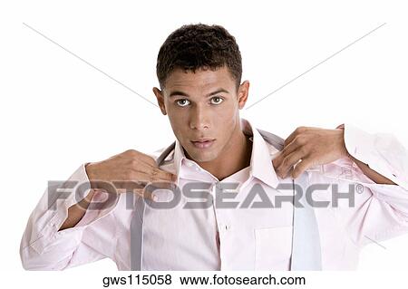 Portrait of a young man putting on a tie View Large Photo Image Stock Photo - Portrait of a young man putting on a tie. Fotosearch