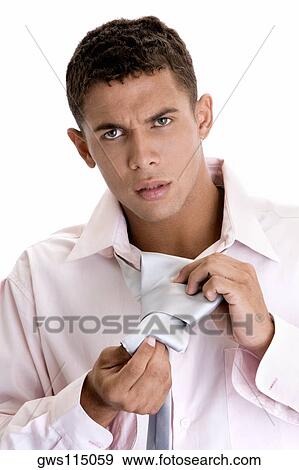 Portrait of a young man putting on a tie View Large Photo Image Stock Photo - Portrait of a young man putting on a tie. Fotosearch