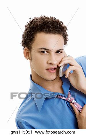 Stock Image - Portrait of a young man using a mobile phone. Fotosearch