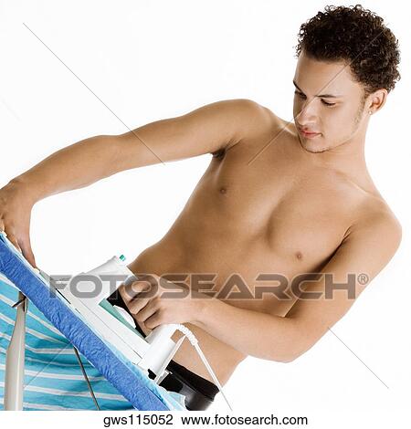 Young man ironing his shirt View Large Photo Image Stock Image - Young man ironing his shirt. Fotosearch