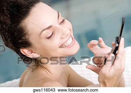 Close-up of a young woman holding a mobile phone View Large Photo Image Stock Image - Close-up of a young woman holding a mobile phone. Fotosearch