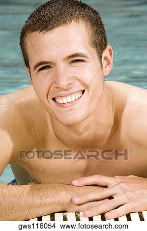 Portrait of a young man smiling in a swimming pool View Large Photo Image Picture - Portrait of a young man smiling in a swimming pool. Fotosearch