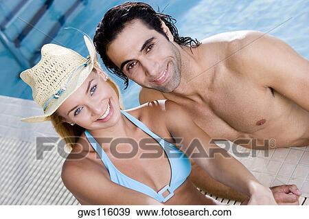 Portrait of a young woman and a mid adult man at the poolside View Large Photo Image Stock Photo - Portrait of a young woman and a mid adult man at the poolside. Fotosearch